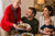 Family gathered around a table for a meal with a newborn